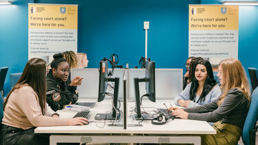 Students on computers, participating in the Support Through Court Pro Bono programme