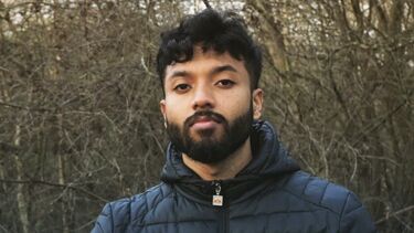 Gaailashwaran stood outside in front of some trees with a warm coat on