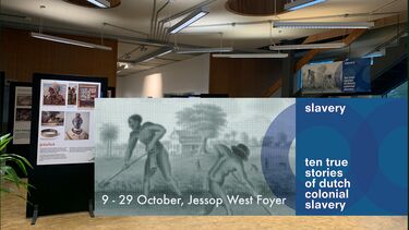 foyer of a building in which you see a poster exhibition and a banner which says slavery ten true stories about Dutch slavery