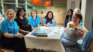 A group of girls sat around a table with art supplies