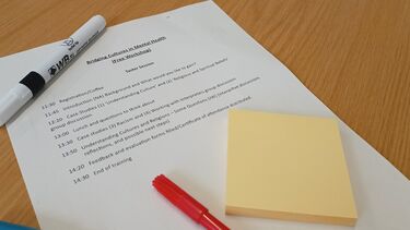 printed schedule of workshop with pen and sticky notes