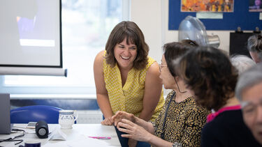 A researcher from the University of Sheffield laughing with members of the local community at an outreach event.
