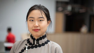 Alumnus Yi Zheng smiles towards the camera