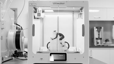 A miniature bicycle being 3D printed