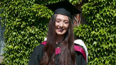 A woman wearing a graduation cap and gown
