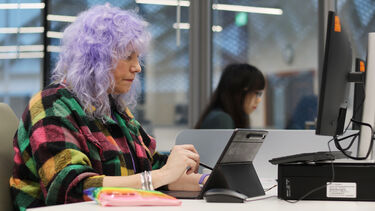 Mature student working independently on a tablet