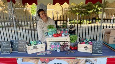 Student selling Soup behind on market 