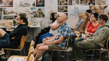 Prospective students and their supporters in an open day department talk 