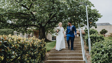 A couple of women walking down to the stairs on their way to their wedding.