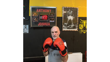 Ian wearing boxing gloves in a fighting position.
