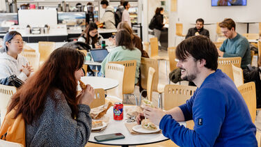 Two people sat at a table eating food