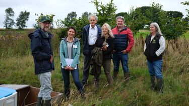 A photo showing our Cardiff social science team visiting North Wyke, one of our field site. There are 6 team members standing in a field amongst long grass .