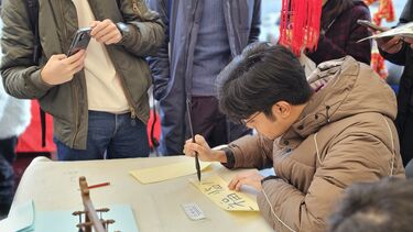 An attendee enjoys our calligraphy stall 