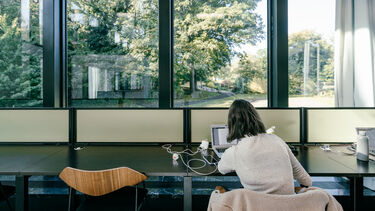 A person sitting at a desk using a laptop computer in Western Bank library