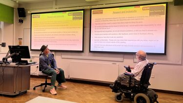 Two men looking at a screen with text on