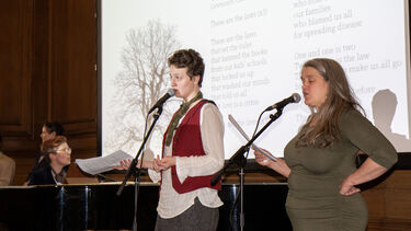 Two singers at a microphone and a musician at a piano 