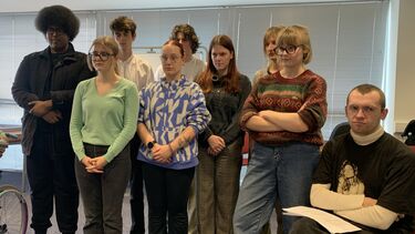 group os students standing quite close together looking quite stern 