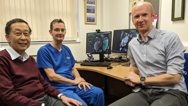 Professor Albert Ong and his colleagues around a computer showing kidney scans generated by AI