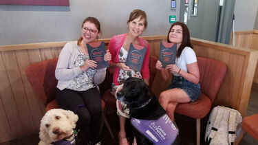 An image of three co-authors holding their book