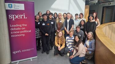 Participants and speakers gather for a photo next to SPERI banner that reads 'Leading the debate on a new political economy'