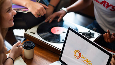 smiling student looking at computer with Homei on