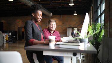 Two people working together in a coworking space.