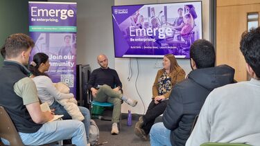 Two speakers at the front of room with audience listening