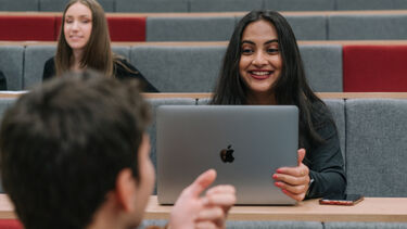 Student using a laptop in a lecture theatre