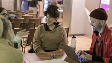 Three PGR students sat at a table in discussion