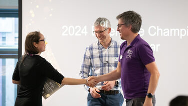 Two staff members shaking hands at presentation 