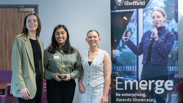 Group shot of team winning award in front of banner 