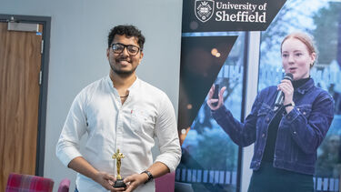 Man standing for photo with award  in front of Emerge banner
