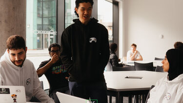 Three students chatting around a table