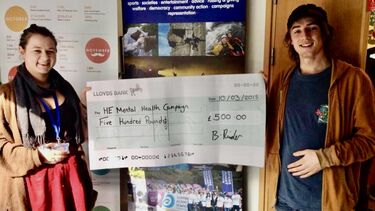 two entrepreneurs holding cheque up