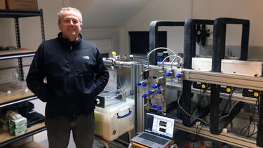 Man standing in front of medical scanner equipment