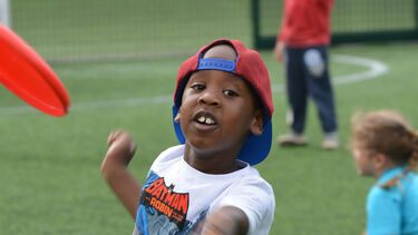 Active Kids. Children playing with frisby outside on the grass