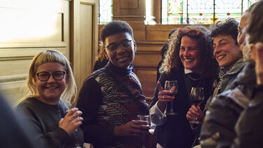 People stood talking with wine glasses in hand 