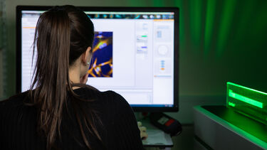 Woman looking at a screen in a room with green light