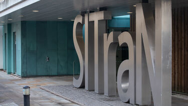 Large metal 'SITraN' sign at building entrance