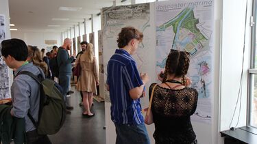 People viewing students design work at the 2024 exhibition in the arts tower