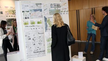 People viewing PGT students design work at the 2024 exhibition in the arts tower