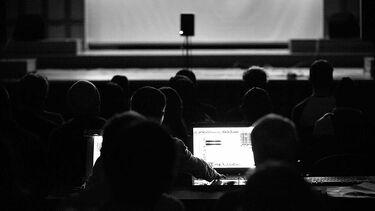 An audience at a concert surrounded by loudspeakers