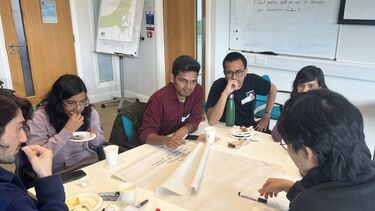 A group of people sitting around a table, in conversation