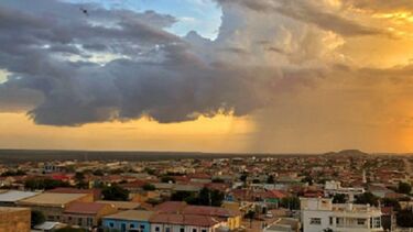 A dramatic sky of grey and yellow clouds over a town