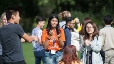 A group of students with a global campus ambassador in a park.