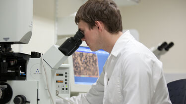Man looking through microscope