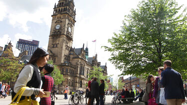Sheffield city centre, with the clock tower of the town hall and people in town