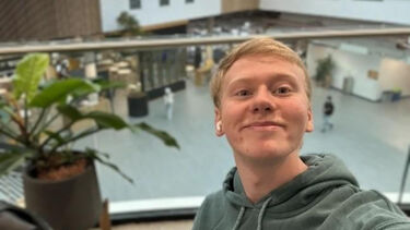 Charles Nelson smiling at the camera while sat in the wave building at Sheffield