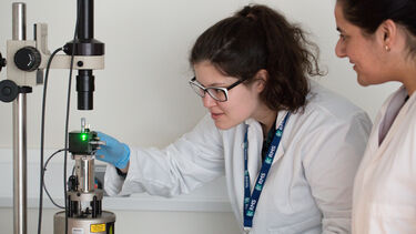 Two people using equipment in the physics AFM facility