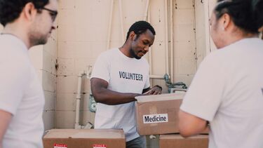 People packing boxes of food and medicine.